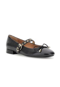 Scarpa flat Mary Jane in pelle nera con fibbia dorata, occhielli e dettaglio a fiocco sulla punta arrotondata, tacco basso e fodera interna beige.