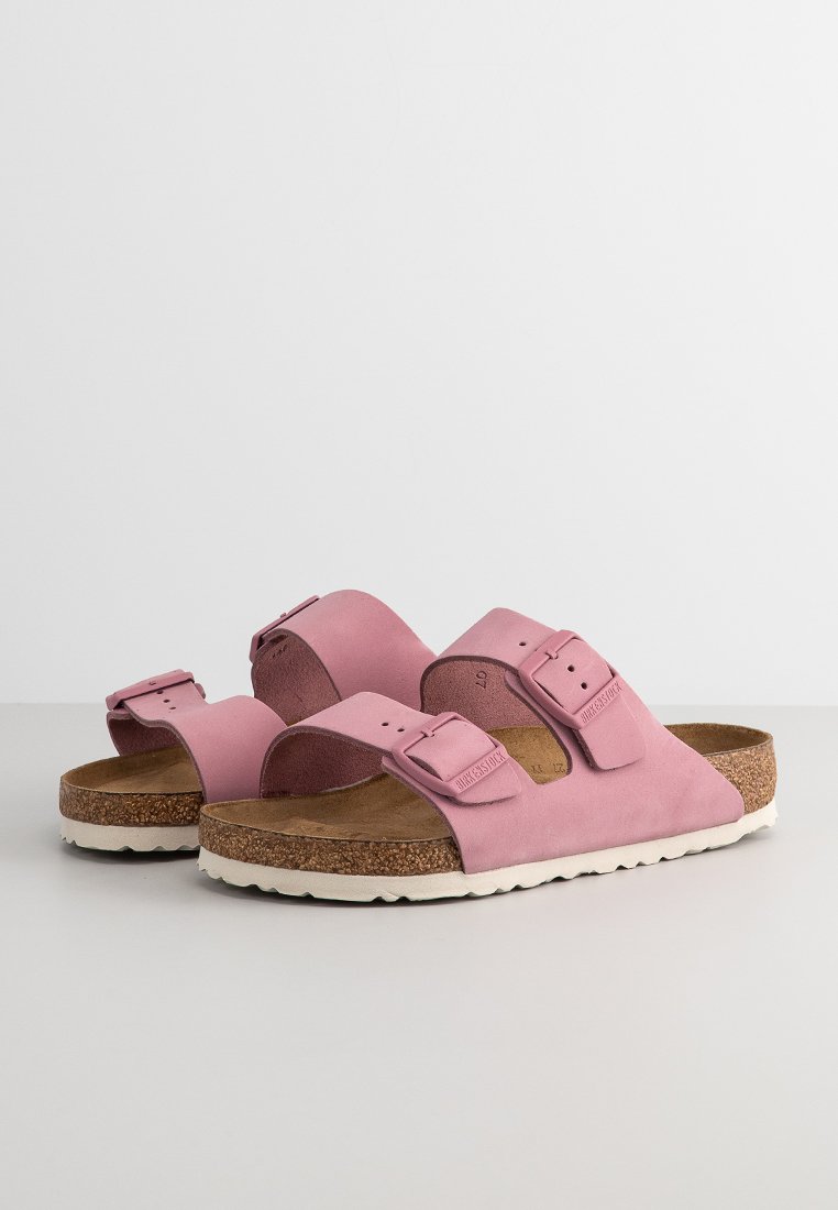 Rosa Wildledersandalen mit zwei verstellbaren Riemen, Korkfußbett und weißer Gummisohle. Sie verfügen über ein flaches Design, eine glatte Textur und keine sichtbaren Muster.