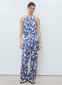 Blauw-witte patroonloze mouwloze top met bijpassende wijde broek, gemaakt van lichte stof; voorzien van een gedurfde bloemenprint en een losse pasvorm.