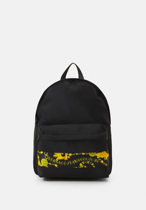 Sac à dos noir de forme arrondie, avec une poche zippée à l'avant arborant un graphique décoratif jaune et un logo, fabriqué en tissu durable.