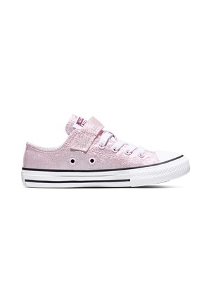 Zapatilla baja de lona rosa con suela de goma blanca, cordones blancos, franja negra en la suela y tira de velcro sobre los cordones.