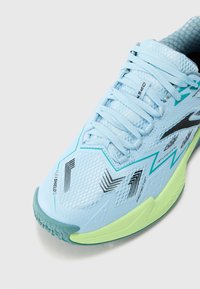 Baskets de sport bleu clair avec tige en maille et accents noirs, dotées d'une semelle flexible en vert lime et d'une texture antidérapante pour l'adhérence.