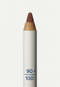 Crayon labial marrón con punta afilada. La carcasa es blanca con un acabado mate, con un estampado azul que dice "90+/100".