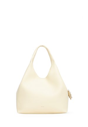 Borsa in morbida pelle color crema con un manico superiore singolo e un piccolo charm decorativo attaccato sul lato.