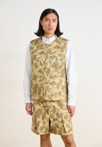 Kamouflage-mönstrad väst med en quiltad textur, i beige och olivf�ärger. Matchas med tillhörande cargoshorts som har fickor och knappar.
