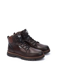 Brown leather lace-up boots with a padded collar, rubber sole, and contrasting stitching. Features logo accent on the side.