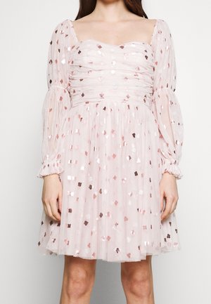 Jasnoróżowa przezroczysta sukienka z długimi bufkami, marszczoną górą oraz metalicznymi różowo-złotymi cekinami w kształcie serca i diamentu na całej powierzchni.