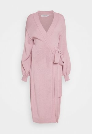 Robe portefeuille en maille rose clair avec manches longues, décolleté en V et ceinture nouée sur le côté, conçue pour les femmes enceintes.