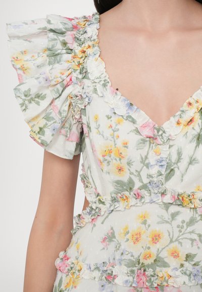 Abito floreale con maniche corte a volant, caratterizzato da una scollatura a V. Tessuto leggero bianco con stampe di fiori rosa, gialli e verdi e rifiniture a volants.