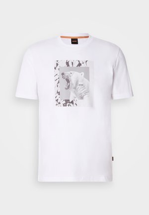 White cotton t-shirt featuring a graphic of a roaring polar bear within a rectangular frame, accented by abstract black and grey patterns.