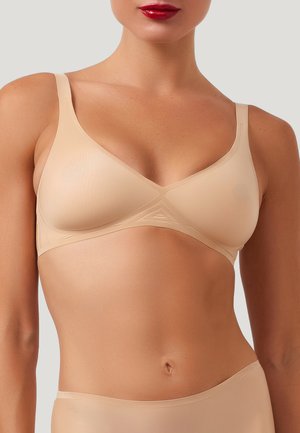 Naadloze nude bh met een driehoekige vorm, verstelbare bandjes en een subtiele geribbelde textuur. Het ontwerp heeft minimalistische accenten.