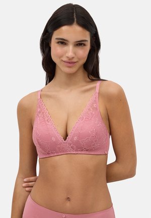 Bralette de encaje rosa con diseño de pico, tirantes ajustables y patrones florales. Textura suave y bordes festoneados que detallan el escote.