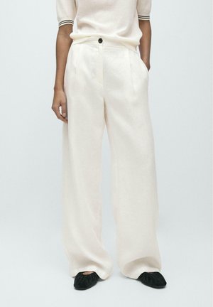 Pantalon en lin à jambes larges de couleur crème clair, avec plis à l'avant, fermeture par bouton noir et poches latérales.