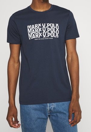 Mand iført marineblå Marc O'Polo t-shirt med hvid tekst, der gentager mærkenavnet og sloganet "Der er ingen fremtid uden natur."