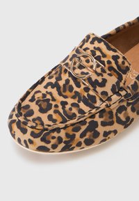 Leopard print moccasin in textured suede with a gold-tone accent. Features a rounded toe and stitching details along the upper.