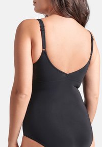 Sort badedragt i ét stykke med justerbare stropper, glat tekstur og lav ryg, med minimal syning og kurver.