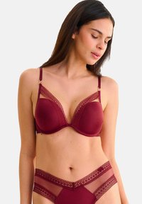 Soutien-gorge bourgogne avec des bordures en dentelle et des détails en mesh contrastés. Bonnets rembourrés et bretelles réglables, avec des accents en métal doré.