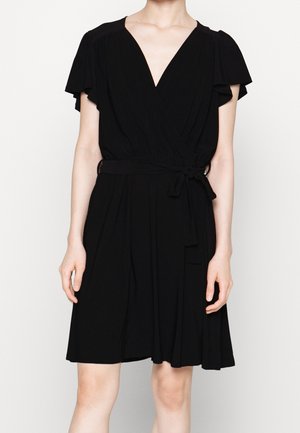 Robe noire drapée avec des manches courtes et légères, décolleté en V et un détail de taille noué. Fabriquée à partir d'un tissu doux et fluide. Longueur genoux.