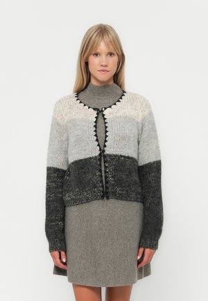 Cardigan en tricot avec un dégradé de gris clair à gris foncé, présentant un col rond, une fermeture à boutons et une bordure contrastante noire le long des bords.