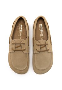Zapatos de ante beige con punta redonda y detalles de cordones. Textura suave con un forro interior marrón y acentos metálicos cerca de los cordones.