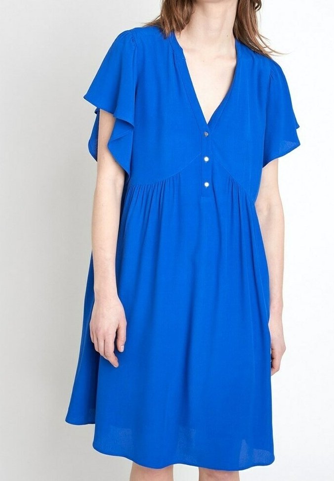 Robe bleue mi-longue avec manches volantées, encolure en V et trois boutons sur le devant, portée par une personne debout sur un fond uni.