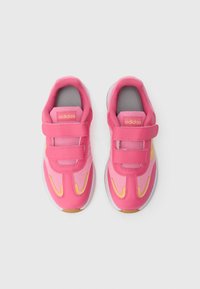 Rožinės Adidas sportbačiai su lipniomis juostelėmis, tinkleliu ir sintetiniais sluoksniais, apvalūs pirštai, pilka pamušalas ir geltoni akcentai šonuose.