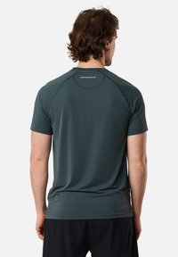 Donkergroene sportt-shirt gemaakt van gladde, lichte stof; heeft een ronde hals, korte mouwen en een logo op de bovenrug.