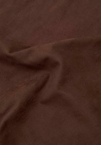 Brunt ruskindstof med en blød, tekstureret overflade, der viser et glat, draperet udseende og subtile variationer i nuancer.