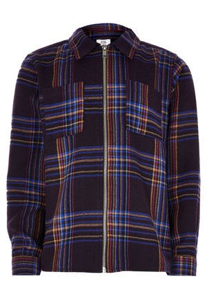 Camisa de cuadros oscura con cremallera, con rayas azules, rojas y amarillas, dos bolsillos en el pecho, mangas largas y cuello.