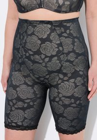 Svarta spetsbyxor med ett blommigt ros-mönster, halvgenomskinlig textur, vågig nederkant och jämn finish med hög midja.