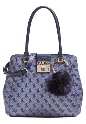 Blue patterned Guess handbag with double handles, detachable strap, gold-tone lock, and a dark blue fluffy keychain charm.