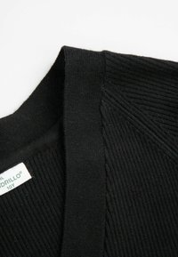 Czarny kardigan dzianinowy z prążkowaną teksturą i dekoltem w kształcie litery V. Posiada metkę materiałową po lewej stronie. Gładkie wykończenie o klasycznym designie.