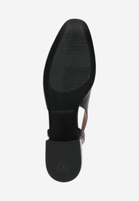 Black heeled sandal with a textured rubber sole. Features a smooth leather upper and a block heel for stability. Designer branding visible.