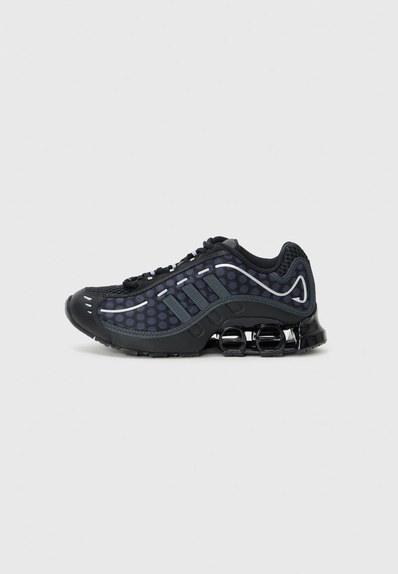 Black athletic shoes with mesh upper featuring circular patterns. Accented with gray stripes, a cushioned sole, and springy black heel supports.