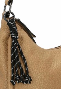 Tan leather handbag with a textured surface, featuring a black and white braided tassel accent attached to a silver hardware ring.