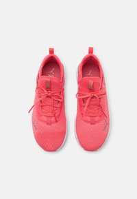 Zapatillas deportivas rosas con parte superior de malla, puntera redondeada y cordones planos; cuenta con una lengüeta y un sutil detalle del logotipo en el costado.