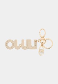 Beige læder nøglering formet som ordet "wow", med en guldfarvet hardware ring og en dekorativ guldaccent.