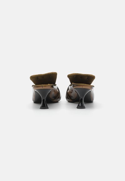 Mules de cuero marrón con un respaldo texturizado, punta afilada y pequeños tacones negros. Presentan una parte superior acolchada y un acabado brillante.
