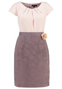 Ljusrosa klänning med korta ärmar, veck vid halsringningen, figursydd midja och lavendelfärgad blommig textur på kjolen; avslutad med en blomsterdetalj på sidan.
