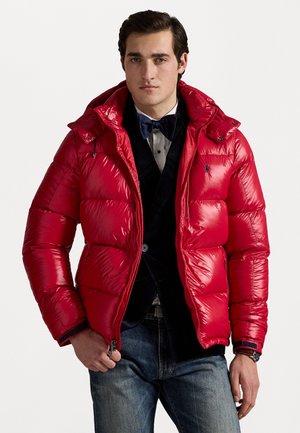 Jachetă puffer roșie cu un finisaj lucios, închidere cu fermoar și glugă detașabilă. Dispune de un design ajustat și textură matlasată cu accente închise.