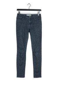 Vaqueros ajustados de color azul oscuro, elaborados en denim, con un diseño de cinco bolsillos, cierre de cremallera y pasadores para cinturón. Textura suave con un desvanecimiento mínimo.