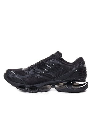 Scarpa sportiva nera con tomaia in rete, sovrapposizioni testurizzate e suola trasparente segmentata per un'ammortizzazione ottimale. Presenta un design con lacci e punta arrotondata.