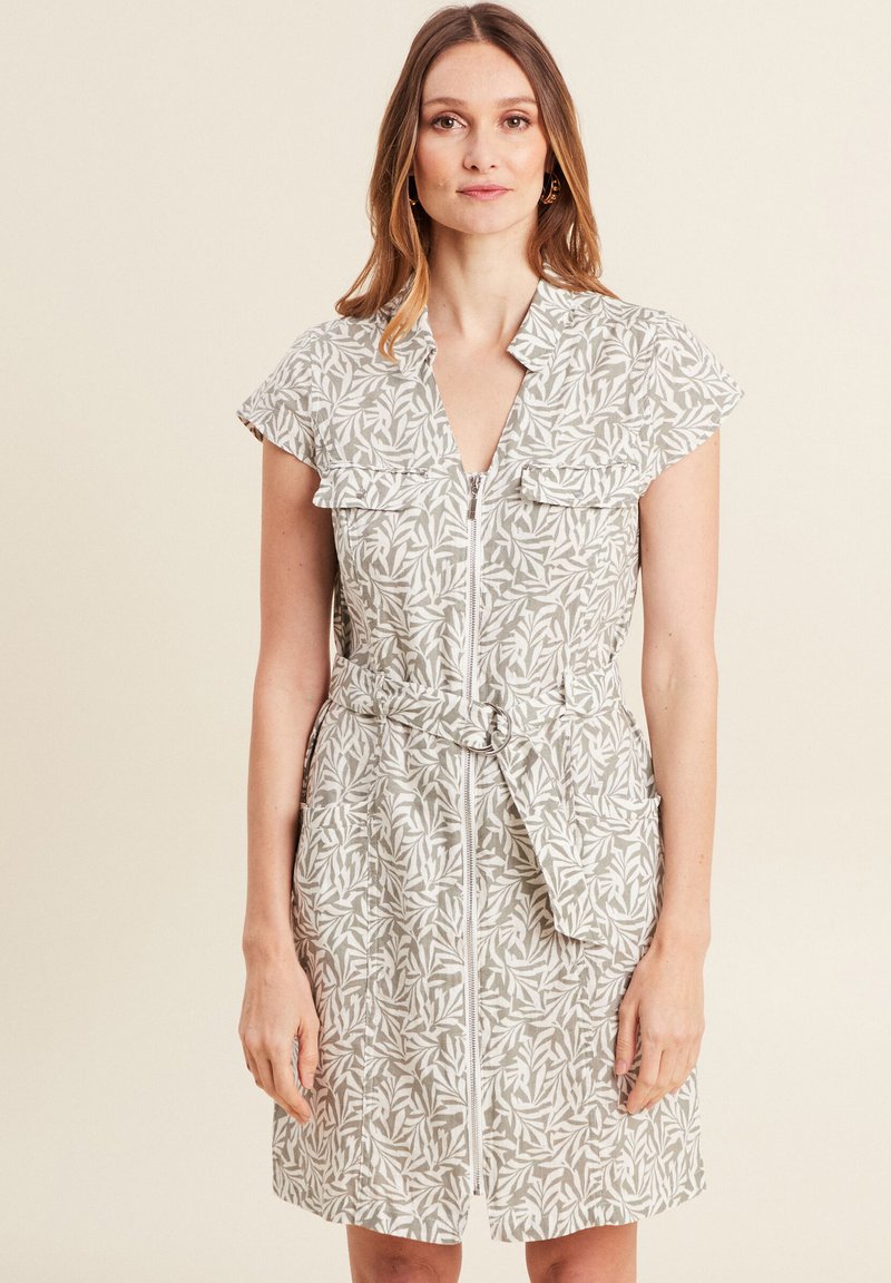 Vestito leggero a maniche corte beige con motivo fogliare, chiusura con zip frontale, due tasche e vita con cintura. Vestibilità casual.