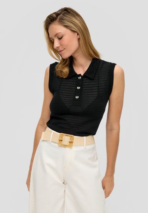 Schwarzes ärmelloses Polohemd aus strukturiertem Stoff, mit Knopfdetails und Kragen, kombiniert mit weißen weitgeschnittenen Hosen und einem beigen Gürtel.