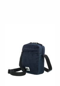 Bolso cruzado de color azul marino hecho de tela texturizada, con un bolsillo frontal con cremallera y una correa negra ajustable. Parche con el logo en la parte frontal.