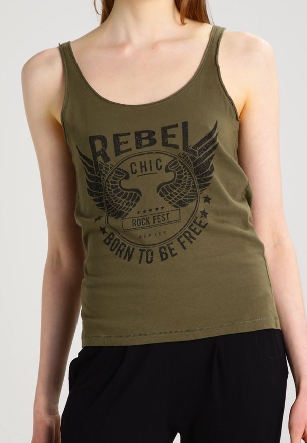 Femme portant un débardeur vert olive avec un emblème ailé noir et un texte indiquant "REBEL CHIC ROCK FEST BORN TO BE FREE."
