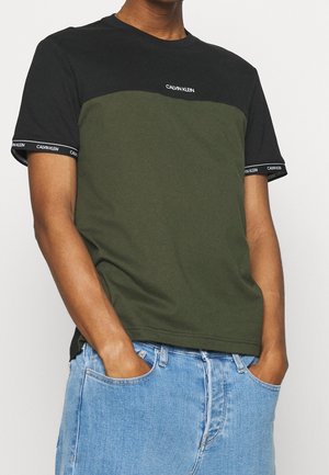 Černé a olivově zelené tričko s krátkými rukávy a kulatým výstřihem, s logem Calvin Klein a kontrastními žebrovanými lemy rukávů.