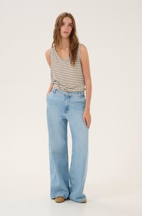 Stribet beige tanktop og lyseblå brede jeans. Tanktoppen har v-hals og knude-detalje; jeansene har høj talje og blød denimtekstur.