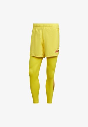 Shorts de sport jaunes au design léger, avec une coupe extensible et des accents rouges contrastants sur les côtés.