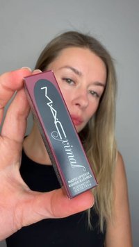 Matte lippenstiftverpakking in bordeauxrood met een zwart logo, rechthoekige vorm en textuurelementen. Het etiket bevat productdetails in witte letters.
